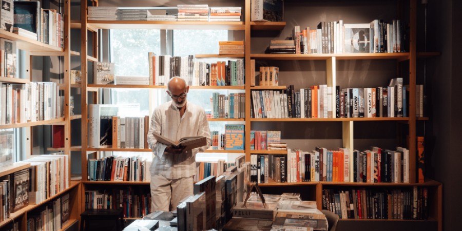 Uomo che legge in libreria
