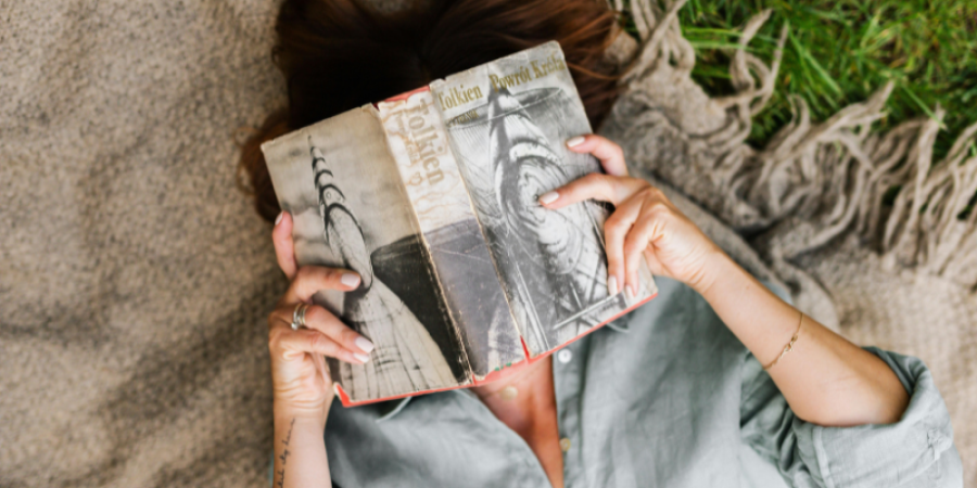 Lettrice impegnata nella lettura di un libro all'aperto