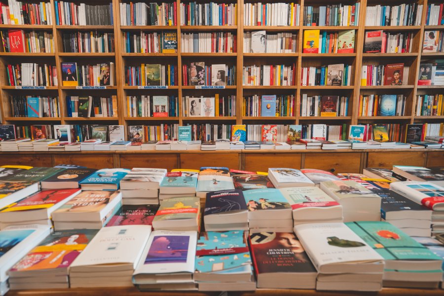 Interno di una libreria Ubik con un tavolo dove sono esposti i libri più venduti del momento